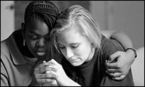 A woman holding and comforting a friend after a disaster.