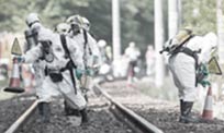 A biohazard clean-up crew dressed in Personal Protective Equipment that are examining a contaminated site.