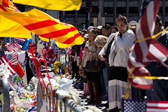 Community members gather around a memorial at a disaster site.