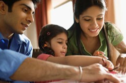 Parents and daughter drawing together.