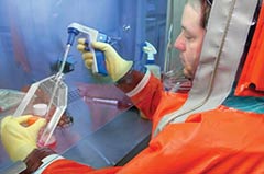 laboratory worker looking into a microscope