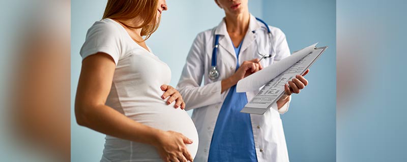 doctor showing a chart to a pregnant woman 