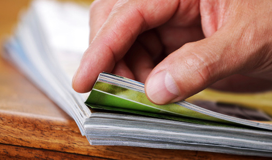 hand reaching for a stack of reports