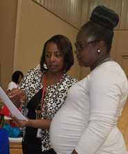 Lisa Moore, Community Health Director for District 1 (left) provides Zika prevention information during the Grenada Health Summit on April 1, 2017. 