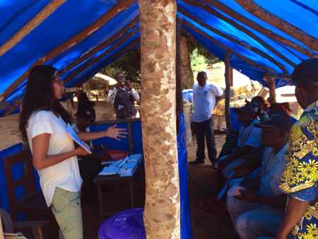 Photo: CDC disease detective Rupa provides an infection control lesson to healthcare workers staffing a health inspection station at the border of Guinea. 