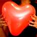 Photo: Two hands holding a heart-shaped balloon.