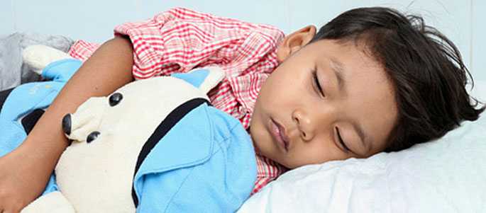 sleeping child holding teddy bear