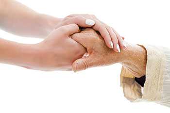 Younger woman holding hands with elderly woman