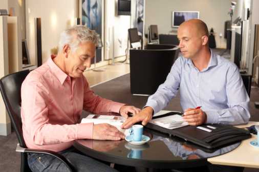 Aged man receiving information from younger man