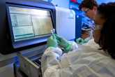 	Thumbnail image of two lab scientists preparing vials for sequencing using a large machine