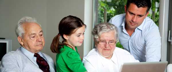 grandparents, father and daughter are together near a computer getting information