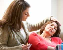 Photo of a woman comforting her mother, who has the flu