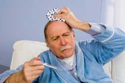 Photo of a man with a thermometer and an ice pack