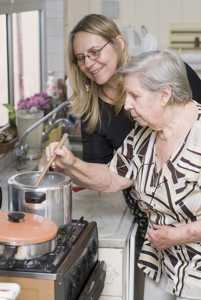 Foto de una mujer observando a su madre cocinar.