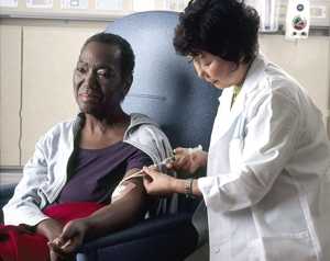 Foto de una enfermera administrando quimoterapia a una paciente de cáncer. Foto cortesía del Instituto Nacional del Cáncer.