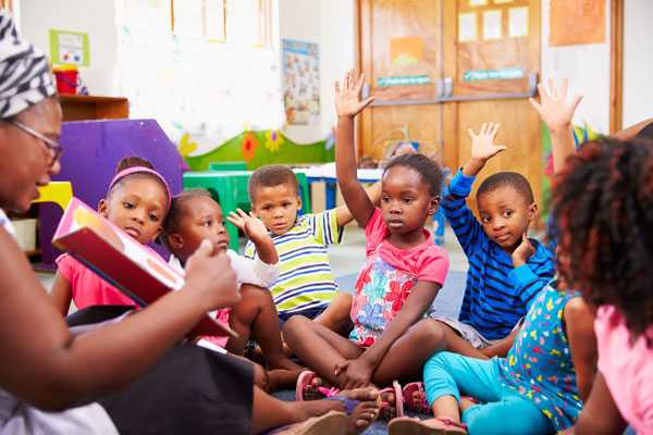 Preschool class raising hands