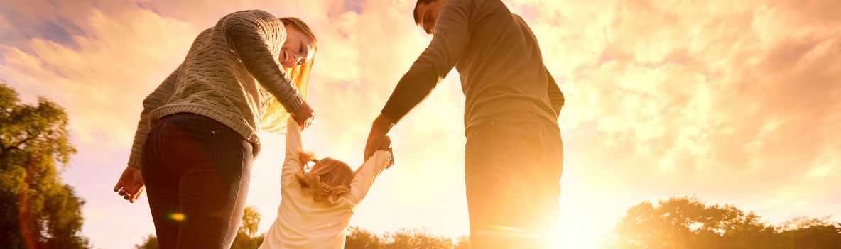 Photo of parents swinging their daughter by their arms