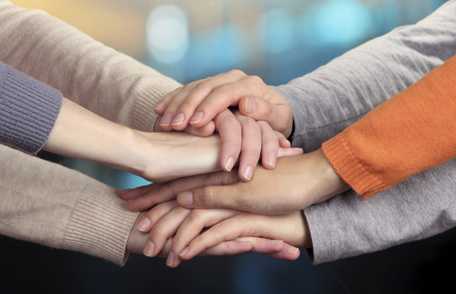 	Photo of hands stacked on top of one another