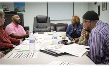 CHWs at a conference table in a meeting.