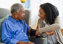 A CHW taking a woman's blood pressure.