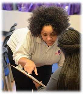 A CHW showing something to a woman with a clipboard.