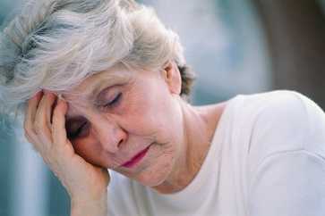 Woman holding her head in her hand.