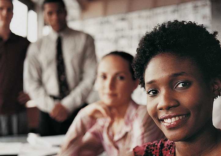 Portrait of a Fashion Designer Sitting in Front of Three of Her Colleagues at a Desk