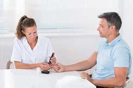 Doctor Using Lancelet On Man's Finger