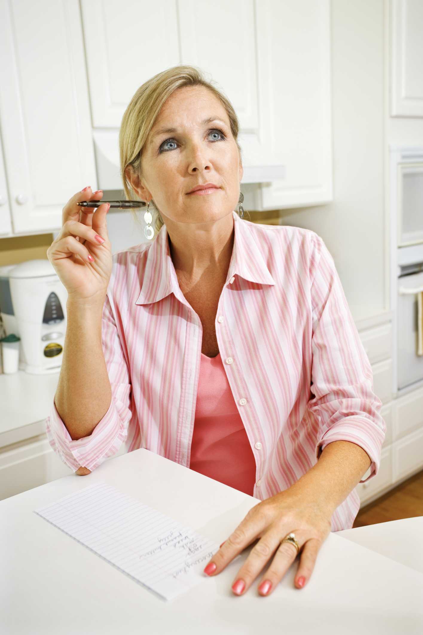 Woman writing a list and thinking