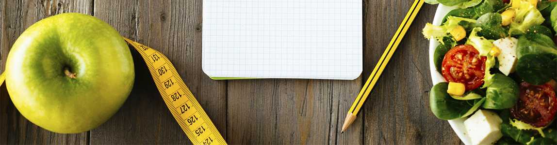  Image of an apple, salad, a notebook and pencil