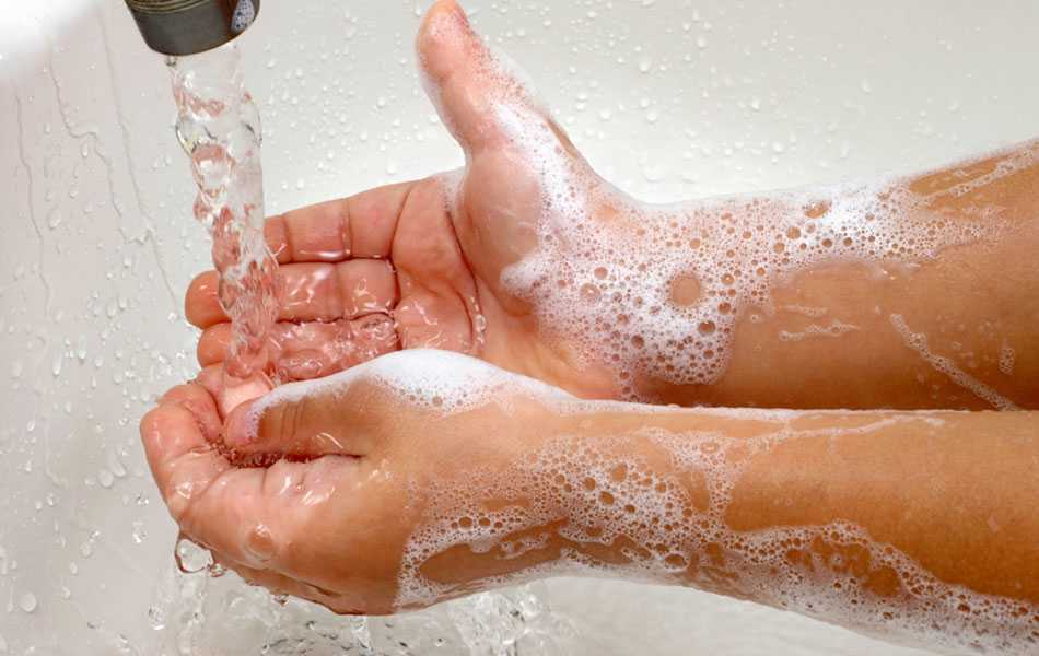 person washing hands with soap and water