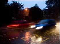 Car Driving on Dark, Wet Road