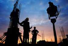 Photo of construction workers with a cloudy sky in the background