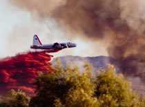 Photo of a plane putting out a fire from the sky.