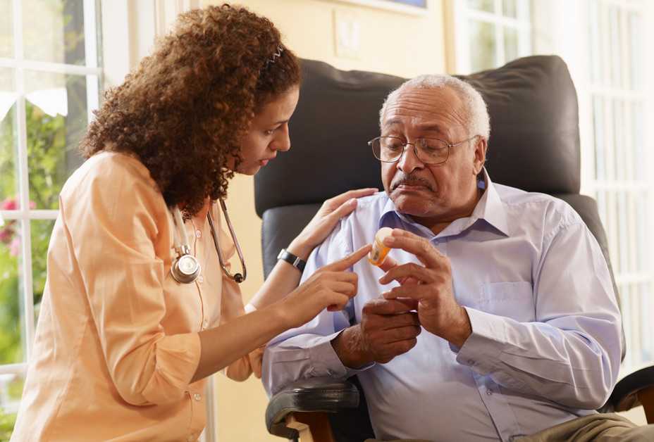 Nurse consulting with senior man about medication