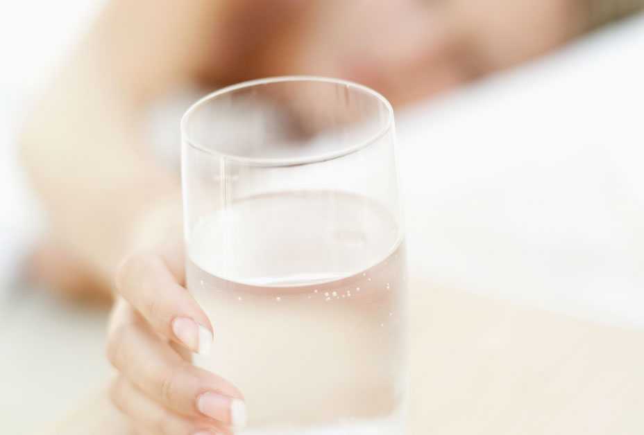 Woman reaching for glass of water