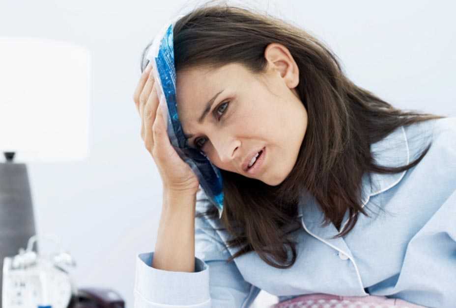 Woman placing wash cloth on head