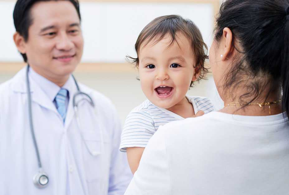 Smiling baby with mother and doctor