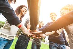 Multiracial friends with hands in stack