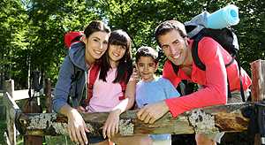 Una familia sale de excursión al bosque llevando mochilas