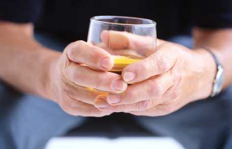 Man's hands holding cocktail glass