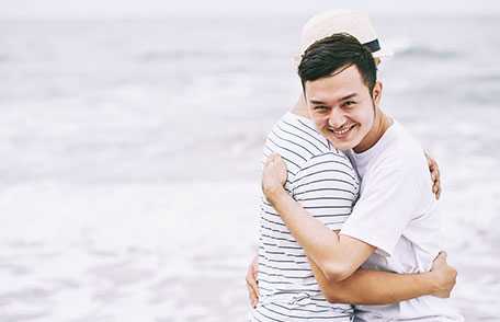 Two men hugging on the beach