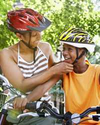 Photo: A mother fastening a helmet on her son