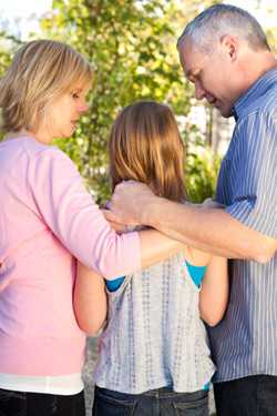 Parents consoling daughter