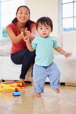 Mother applauding toddler walking