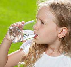 Niña sudando y tomando agua