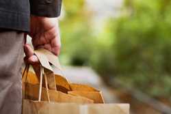 Man's hand holding shopping bag