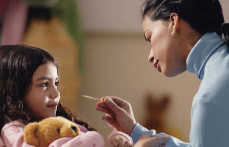 Mother taking daughter's temperature