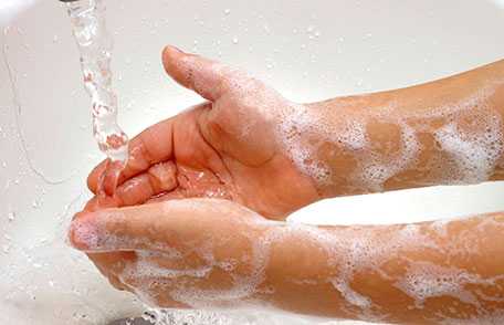 Soapy hands under faucet