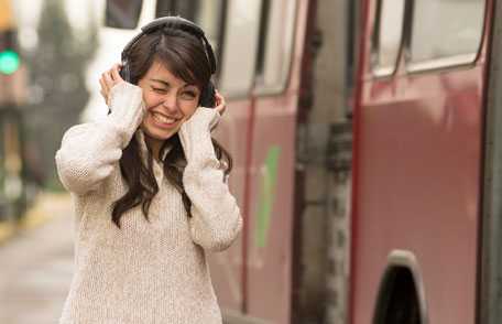 Woman clutching headphones and wincing